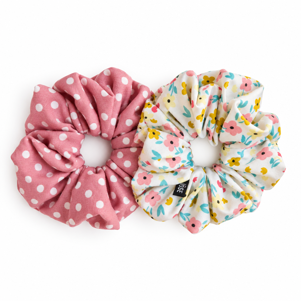Floral scrunchie above pink polka-dot scrunchie on pure white